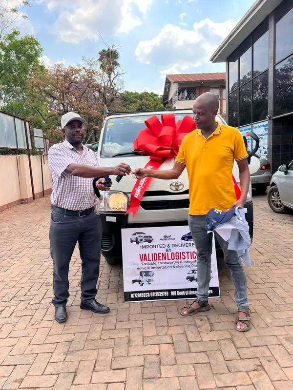 Keys handed over for a white Toyota HiAce, with the Validen &ldquo;Imported & delivered&rdquo; board in front