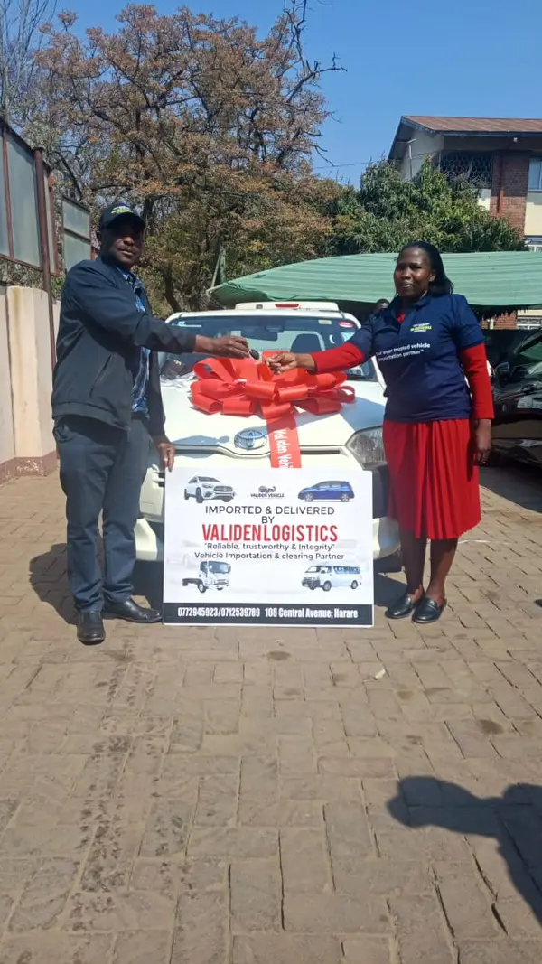 Handover of a white Toyota, red bow on the bonnet and the Validen board in front